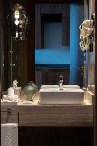 a bathroom counter with a sink and a mirror at WAW Hotel Suites King Abdullah District in Riyadh