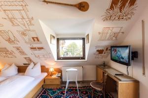 een slaapkamer met een bed en een tv aan de muur bij Hotel Lindenhof Hubmersberg in Pommelsbrunn