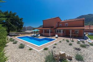a house with a swimming pool in front of it at Villa Lavandula in Tribalj