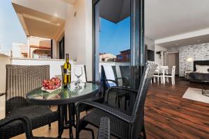 uma sala de jantar e sala de estar com mesa e cadeiras em Deluxe Apartments A&A em Rovinj