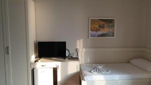 a room with a bed and a television on a desk at Joel Residence in Durrës