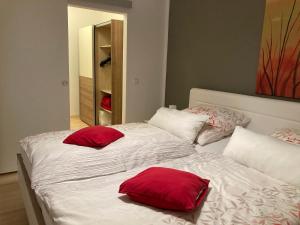 ein Schlafzimmer mit 2 Betten und roten Kissen darauf in der Unterkunft Ferienwohnung Wittker in Bruttig-Fankel
