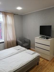 a bedroom with a bed and a tv on a dresser at Varnu Apartment in Rīga