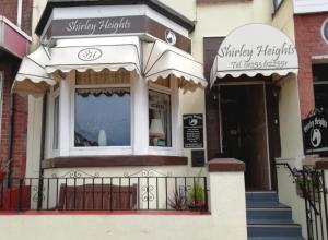Shirley Heights Hotel في بلاكبول: متجر به مظلة على مبنى