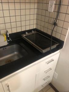 een keuken met een wastafel en een betegelde muur bij Atlântico Flat Apt 210 in Natal