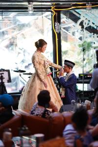 a bride and groom feeding each other on a stage at Letana Hotel in Bang Phli