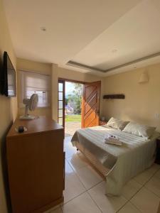 a bedroom with a bed and a desk with a fan at Pousada Village Tere in Teresópolis