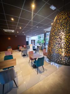 a waiting room with tables and chairs and a giant egg at Best Western Hotel & SPA Pau Lescar Aeroport in Lescar