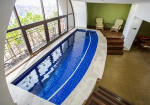 a large swimming pool in a building with a window at Estanplaza Paulista in Sao Paulo