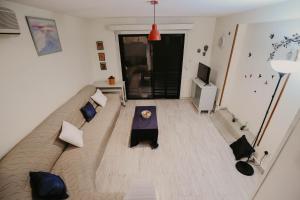 ein Wohnzimmer mit einem Sofa und einem Tisch in der Unterkunft Pirgos beach house in Larnaka