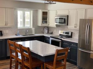 a kitchen with white cabinets and a table with chairs at Summit Ridge 4 in Blue Mountains