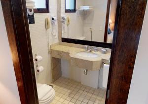 a bathroom with a sink, toilet and mirror at Estanplaza Paulista in São Paulo