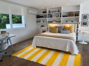a bedroom with a bed and a desk and a window at Tropical Contemporary Suites in Paraty