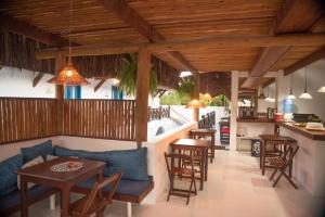 an open kitchen and dining room with wooden ceilings at Vila Mucugê Pousada e Hostel in Arraial d'Ajuda