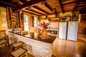 a kitchen with a refrigerator and a counter with flowers on it at Sítio São Judas Tadeu in Viçosa do Ceará