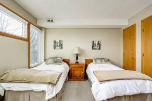 Un dormitorio con dos camas y una ventana. en Ski In Out Mountainside Chalet 83001, en Blue Mountains