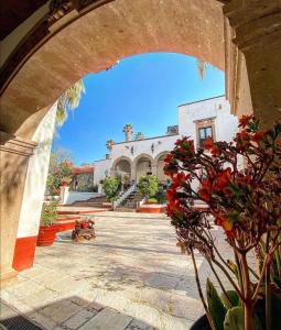 - une vue sur un bâtiment depuis une arche dans l'établissement Hotel Spa Hacienda Real la Nogalera, à Tequisquiapan