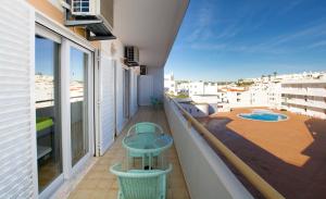 een balkon met een tafel en stoelen en een zwembad bij Apart. Farol - Praia Carvoeiro in Carvoeiro