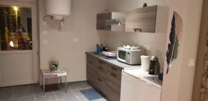 una cucina con forno a microonde sopra un bancone di Bel appart moderne Roanne a Roanne Altre 3 foto