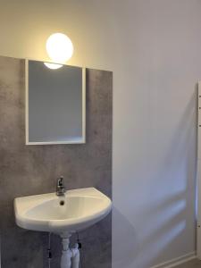 y baño con lavabo blanco y espejo. en Rosenfors Vandrarhem en Borgholm