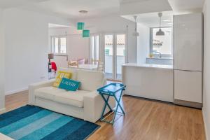 ein Wohnzimmer mit einem weißen Sofa und einer Küche in der Unterkunft Cascais Twin Apartments - Daydream PT in Cascais