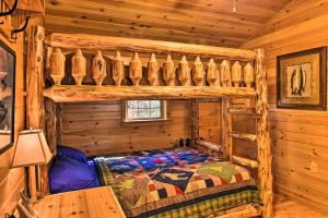 ein Schlafzimmer mit einem Bett in einem Blockhaus in der Unterkunft Cozy Anchors Away Cabin Hideaway with Fire Pit! in Parsons