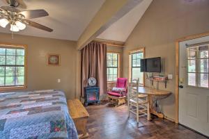 Schlafzimmer mit einem Bett, einem Tisch und einem TV in der Unterkunft Peaceful Wild Rose Cabin with Private Hot Tub! in Broken Bow