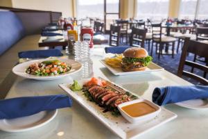 a table with plates of food and a hamburger and fries at Bay Club Hotel and Marina in San Diego