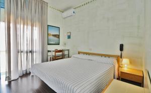 Un dormitorio con una gran cama blanca y una mesa en Hotel Antonella, en Caorle