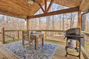 een afgeschermde veranda met een grill en een fornuis bij Creek-View Getaway with Deck, Yard, and Fire Pit! in Summerville