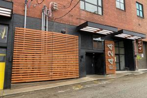 - un bâtiment avec une grande porte en bois dans une rue dans l'établissement 3E-*New* Apt 10 min to Children’s Hospital, slps 4, à Pittsburgh