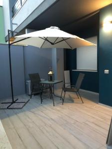 Decimomannu的住宿－Nuovo appartamento Elegante,curato nei dettagli，桌子、椅子和雨伞