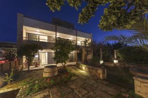 Un gran edificio con luces en el frente. en Terpsis Estate, en La Canea