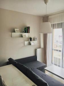 een woonkamer met een bank, een tafel en een raam bij Квартира в Анталии in Antalya