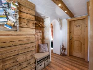 a room with a wooden wall and a chair at Chalet Hüttenzauber in Kirchberg in Tirol +11 photos