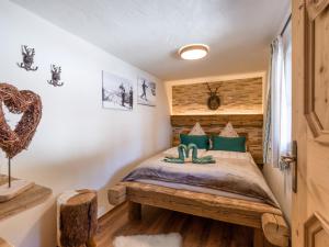 een slaapkamer met een bed met groene kussens bij Chalet Hüttenzauber in Kirchberg in Tirol