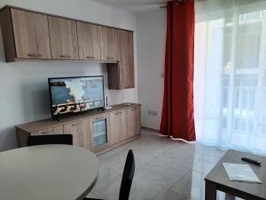 Il comprend un salon avec une télévision, une table et une salle à manger. dans l'établissement Side Sea View Porto Paolo B, à San Pawl il-Baħar
