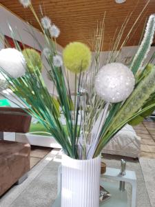 a white vase filled with flowers on a table at Apartment H2 Düsseldorf in Düsseldorf