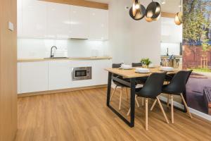 kuchnia i jadalnia ze stołem i krzesłami w obiekcie Royal Manu Apartment NETFLIX w Łodzi