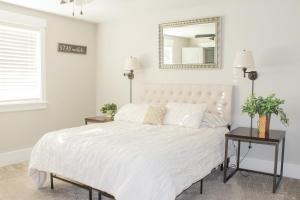 a bedroom with a white bed with a mirror on the wall at Family Friendly Home - Utah Valley Sanctuary in Orem