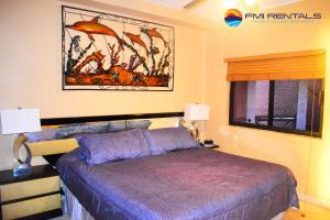 佩納斯科港的住宿－Marina Pinacate B-405，卧室配有一张床,墙上挂有绘画作品