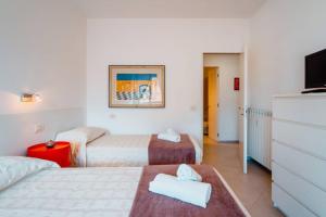 a hotel room with two beds and a flat screen tv at Grand Central Ventimiglia - WiFi & Parking in Ventimiglia