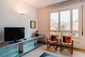a room with a desk with a television and two chairs at Grand Central Ventimiglia - WiFi & Parking in Ventimiglia
