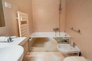a bathroom with a sink and a tub and a toilet at Grand Central Ventimiglia - WiFi & Parking in Ventimiglia +22 photos