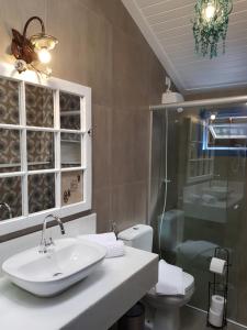 a bathroom with a sink and a shower and a toilet at Suite Tomaz Gonzaga in Ouro Preto