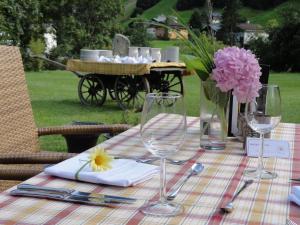 - une table avec des verres à vin et un vase de fleurs dans l'établissement Hotel Nova, à Gaschurn