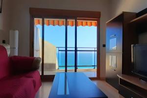 a living room with a couch and a large window at Descansar, sonreír, sentir. Paraíso frente al mar in Santa Pola