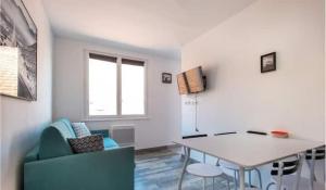 a living room with a table and a blue couch at Pied à terre Wimereux à 2 pas de la plage et du centre in Wimereux