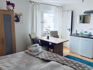 a bedroom with a bed and a table and a kitchen at Conny's Bistro und Pension in Rackwitz +1 photo