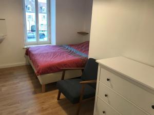 a bedroom with a bed and a chair and a window at Jolie maison à Wissant proche de la plage in Wissant